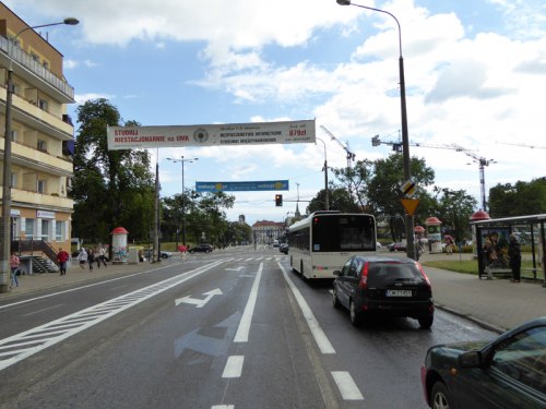 Pas rowerowy prowadzi do Placu NOT przez który należy przejechać w kierunku Alei Solidarności stosując się do znaków drogowych i sygnalizacji świetlnej.