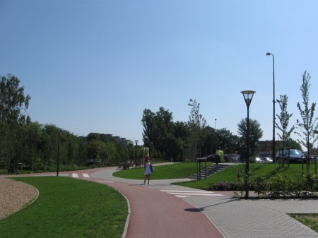 Czytelnie poprowadzona droga rowerowa po terenie rekreacyjnym.