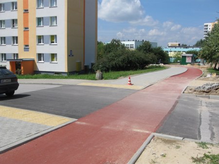Przejazd już z warstwą ścieralną asfaltu - na szczególną uwagę zasługuje brak krawężnika w poprzek drogi rowerowej.