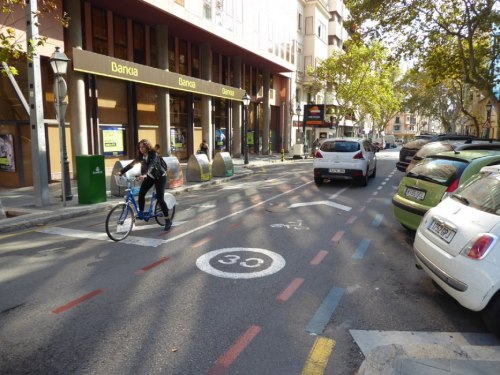 Strefa tempo 30, odpowiednie oznakowanie dla rowerzystów i użytkowniczka roweru z miejskiej wypożyczalni.