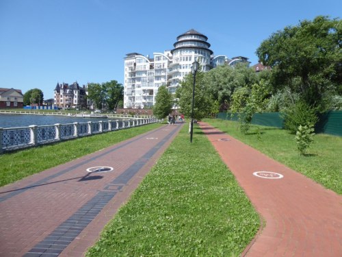 Droga rowerowa w pobliżu jeziora zlokalizowanego w centrum miasta / Велодорожка в окрестностях пруда, расположенного в центре города
